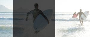 Surfing on the beach with friends, illustrating a fun and adventurous lifestyle, ideal imagery for financial planning or lifestyle branding.