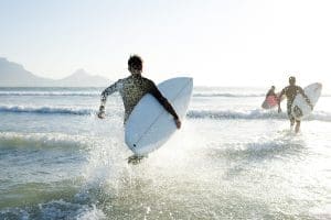 Surfer riding a wave at the beach, promoting financial planning and adventure.